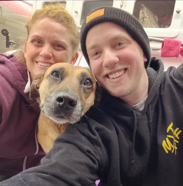 Ashleigh smiling with a dog near the grooming table