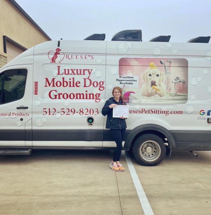 Ashleigh and a teammate with a dog after grooming